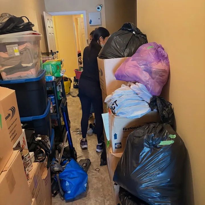 MOOP mid-session hauling donation bags out of a packed garage