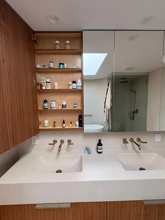 Bathroom medicine cabinet organized by shelf in a Vancouver home