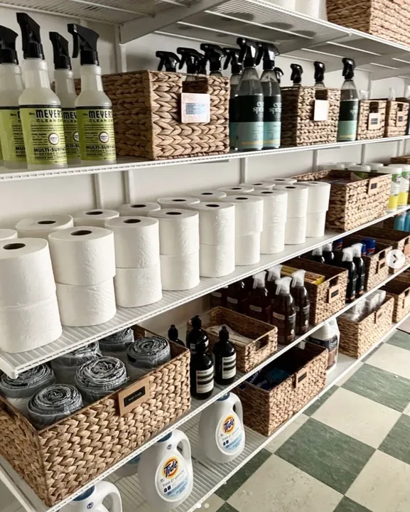 Supply pantry organized with woven baskets and labelled zones