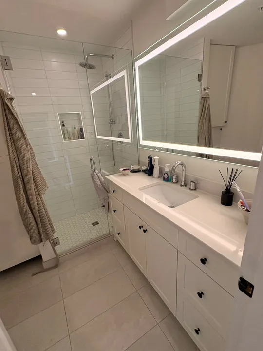Organized ensuite bathroom vanity and shower in a Vancouver home