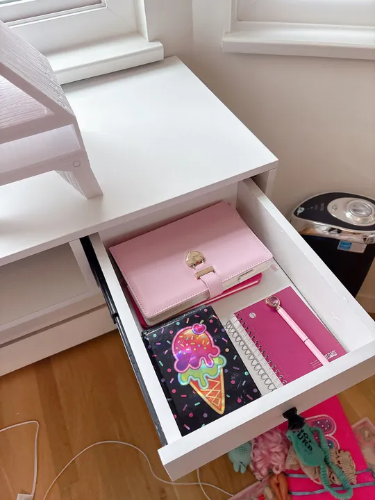Kids' desk drawer tidied with notebooks and pens in place